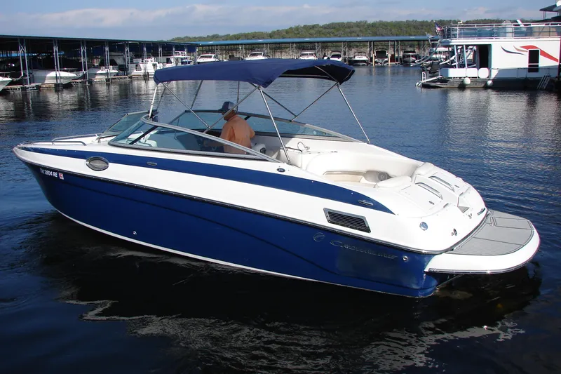 Slide: The Image of 2008 Crownline 270 BR boat docked in marina, featuring blue and white design. - 5