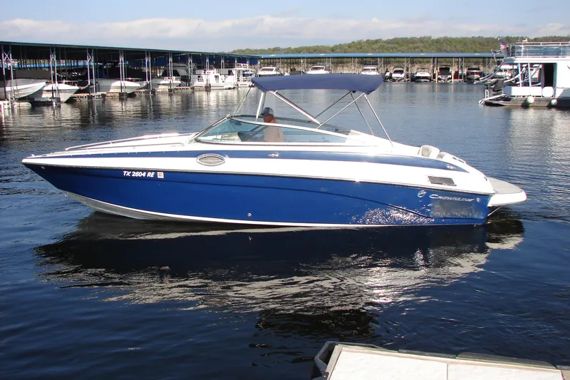 Slide: The Image of 2008 Crownline 270 BR boat with blue hull, docked in a marina. - 6
