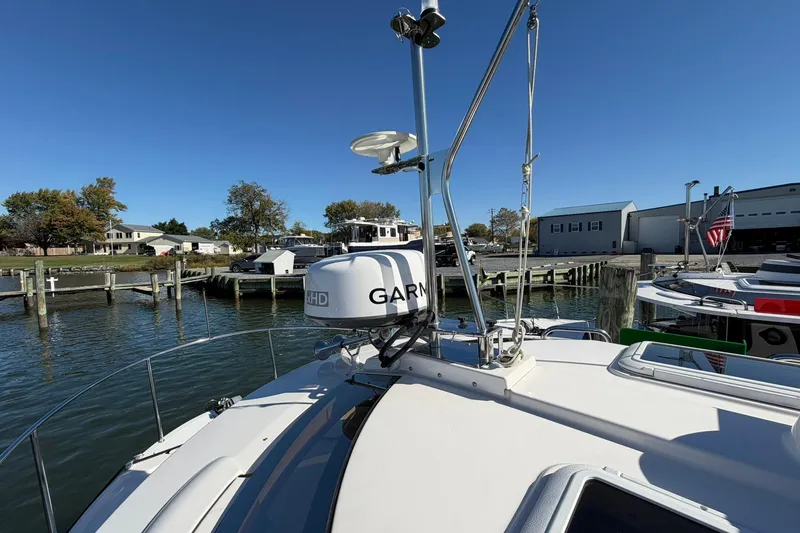 Slide: The Image of 2023 Ranger Tugs R-25 boat docked, featuring Garmin radar, under clear blue sky. - 10