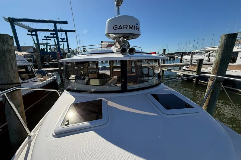 Slide: The Image of 2023 Ranger Tugs R-25 boat docked, featuring Garmin equipment, in a sunny marina setting. - 11