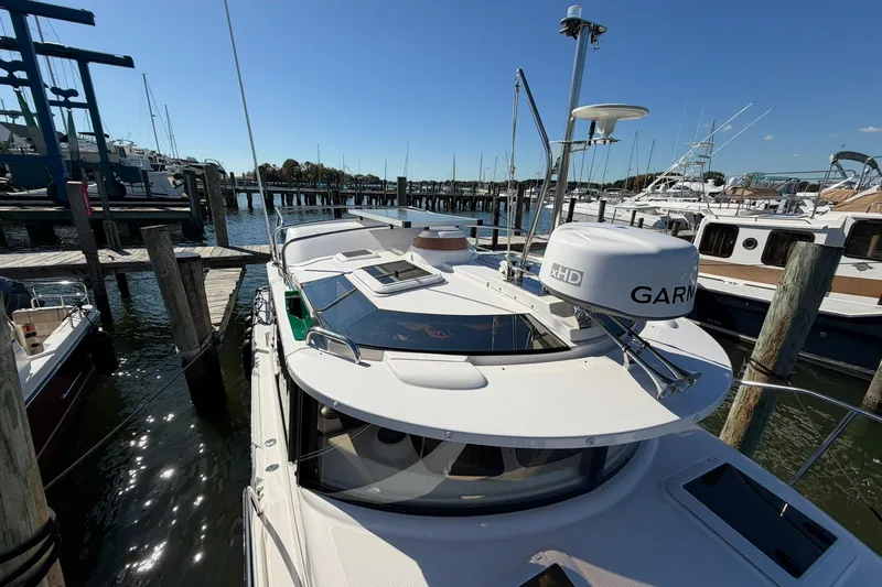 Slide: The Image of 2023 Ranger Tugs R-25 docked at marina, featuring Garmin radar and sleek design. - 12