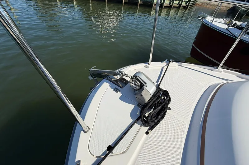 Slide: The Image of 2023 Ranger Tugs R-25 boat deck with anchor and rope, docked by the water. - 15