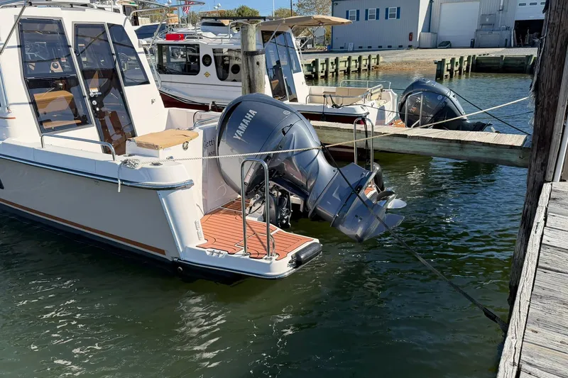 Slide: The Image of 2023 Ranger Tugs R-25 boat docked with Yamaha outboard motor. - 17