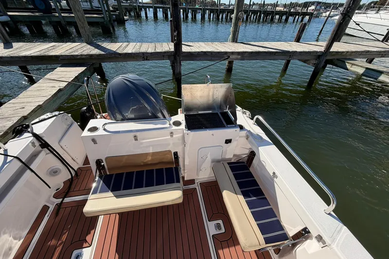 Slide: The Image of 2023 Ranger Tugs R-25 boat deck with seating and grill by the water. - 23