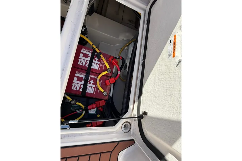 Slide: The Image of Battery compartment of 2023 Ranger Tugs R-25 boat with visible wiring and components. - 25