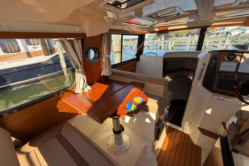 Slide: The Image of Interior of 2023 Ranger Tugs R-25 boat with wooden table and seating area. - 28