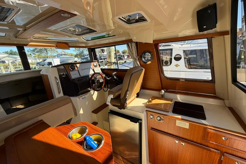 Slide: The Image of Interior of 2023 Ranger Tugs R-25 boat with helm, kitchen, and seating area. - 29