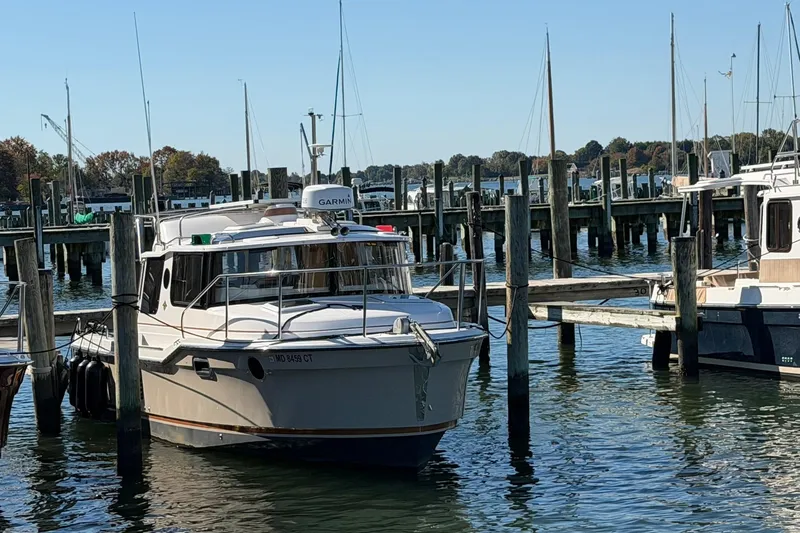 Slide: The Image of 2023 Ranger Tugs R-25 docked at a marina with sailboats in the background. - 3