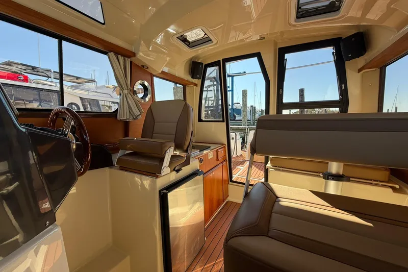 Slide: The Image of Interior of 2023 Ranger Tugs R-25 boat, featuring seating and helm station. - 31
