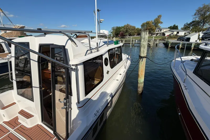 Slide: The Image of 2023 Ranger Tugs R-25 docked at a marina, showcasing sleek design and modern features. - 4
