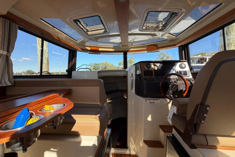 Slide: The Image of Interior of 2023 Ranger Tugs R-25 boat, featuring helm and seating area with skylights. - 45