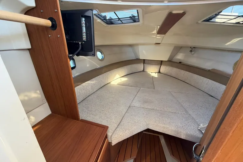 Slide: The Image of 2023 Ranger Tugs R-25 interior cabin with cozy seating and wooden accents. - 46