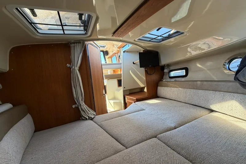 Slide: The Image of 2023 Ranger Tugs R-25 interior cabin with cozy bed and natural light. - 49