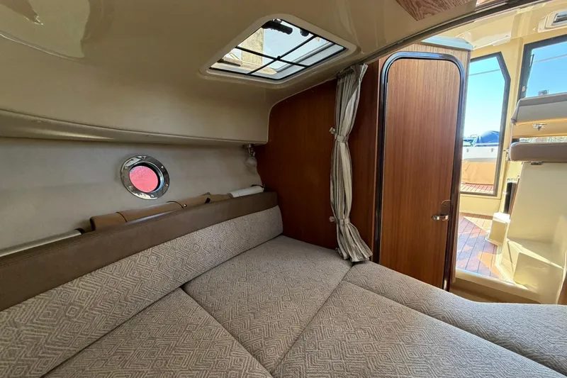Slide: The Image of 2023 Ranger Tugs R-25 interior cabin with cozy bed and wooden door. - 51