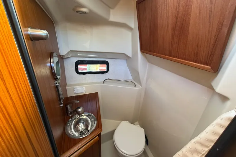 Slide: The Image of 2023 Ranger Tugs R-25 boat bathroom with wood accents and compact design. - 53
