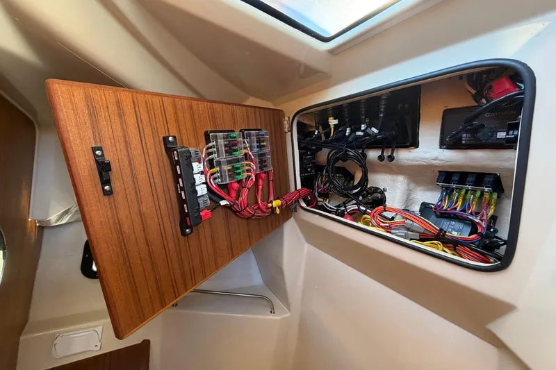 Slide: The Image of Electrical panel inside 2023 Ranger Tugs R-25 boat, showcasing wiring and components. - 54