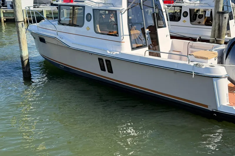 Slide: The Image of 2023 Ranger Tugs R-25 boat docked in marina, side view. - 6