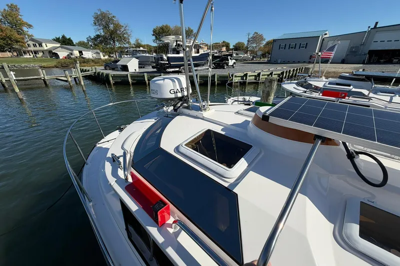 Slide: The Image of 2023 Ranger Tugs R-25 boat docked, featuring solar panels and Garmin equipment. - 9