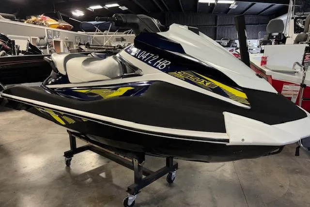 Slide: The Image of 2017 Yamaha WaveRunner VX Deluxe jet ski in showroom, black and white with yellow accents. - 1