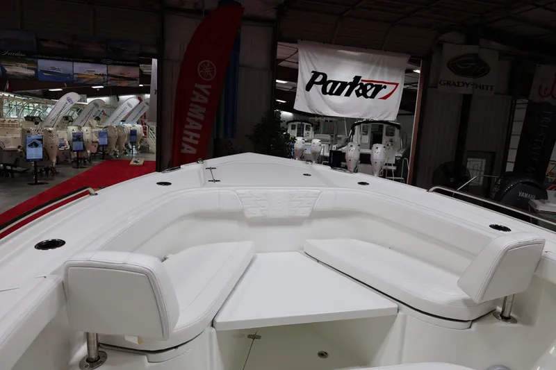 Slide: The Image of 2026 Parker 274 Fathom boat interior at a showroom, featuring white seating and Yamaha branding. - 13