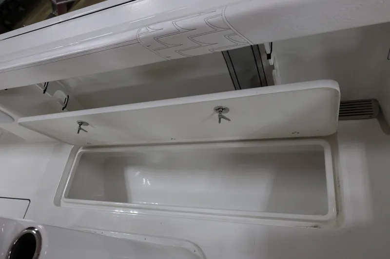 Slide: The Image of 2026 Parker 274 Fathom boat storage compartment with open lid, showcasing interior space. - 17