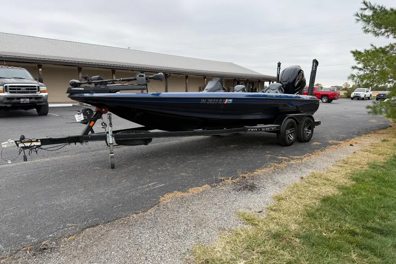 Slide: The Image of 2022 Skeeter ZXR21 boat on trailer in parking lot, surrounded by vehicles. - 5