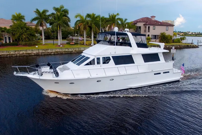 Slide: The Image of 1988 Viking 63 Cockpit Motor Yacht cruising on a scenic waterway. - 0