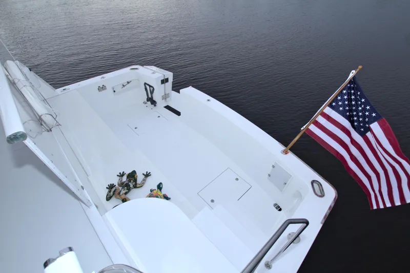 Slide: The Image of 1988 Viking 63 Cockpit Motor Yacht with American flag on calm water. - 17
