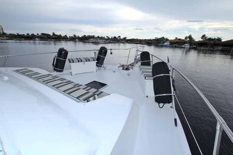 Slide: The Image of 1988 Viking 63 Cockpit Motor Yacht deck with seating, docked on a calm waterway. - 23