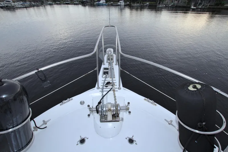 Slide: The Image of Bow view of 1988 Viking 63 Cockpit Motor Yacht on calm water. - 25
