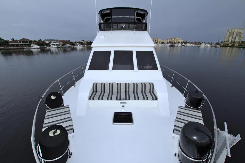 Slide: The Image of 1988 Viking 63 Cockpit Motor Yacht on calm waters, front deck view. - 26