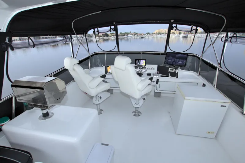 Slide: The Image of Cockpit of 1988 Viking 63 Cockpit Motor Yacht with white seating and navigation equipment. - 32