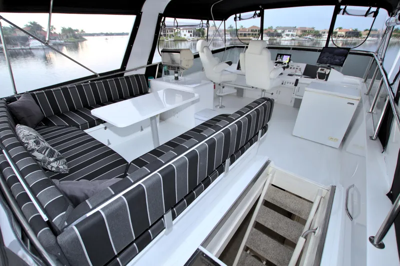 Slide: The Image of 1988 Viking 63 Cockpit Motor Yacht interior with striped seating and helm station. - 38