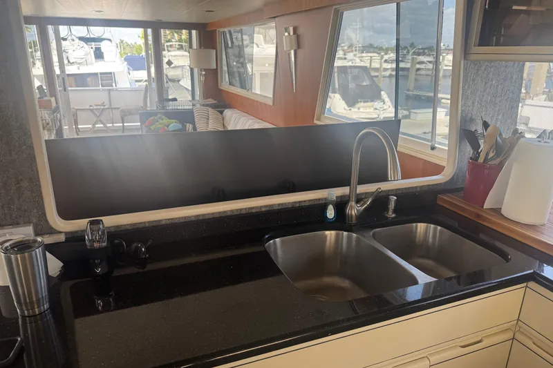 Slide: The Image of Interior of 1988 Viking 63 Cockpit Motor Yacht with kitchen sink and marina view. - 42