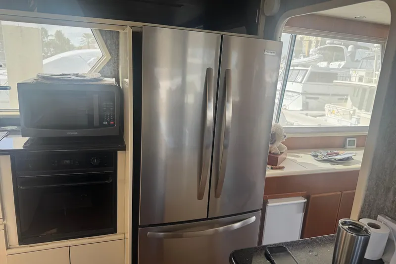 Slide: The Image of Kitchen area inside a 1988 Viking 63 Cockpit Motor Yacht with appliances and window view. - 43