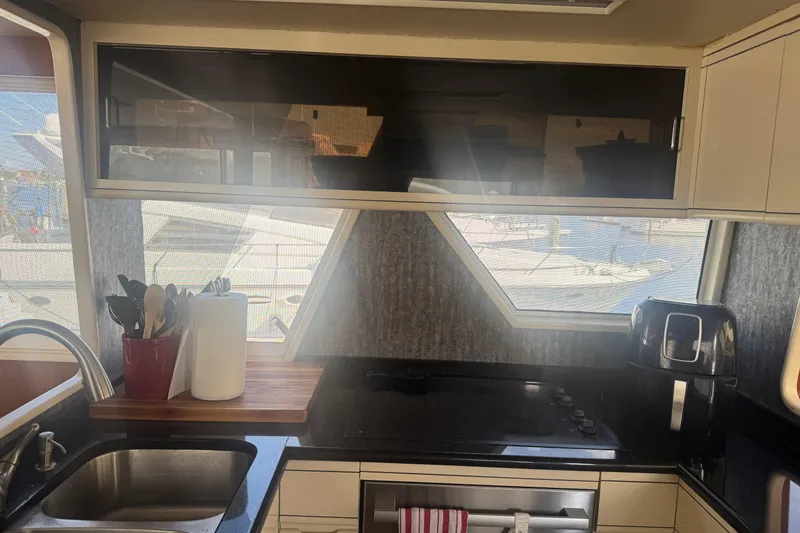 Slide: The Image of Interior kitchen of 1988 Viking 63 Cockpit Motor Yacht with modern appliances and window views. - 44