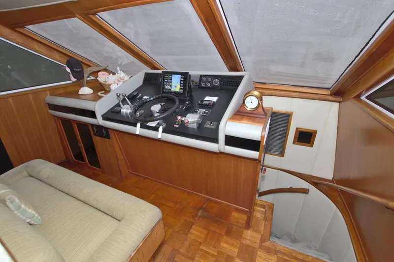 Slide: The Image of 1988 Viking 63 Cockpit Motor Yacht helm with navigation equipment and wooden interior. - 45