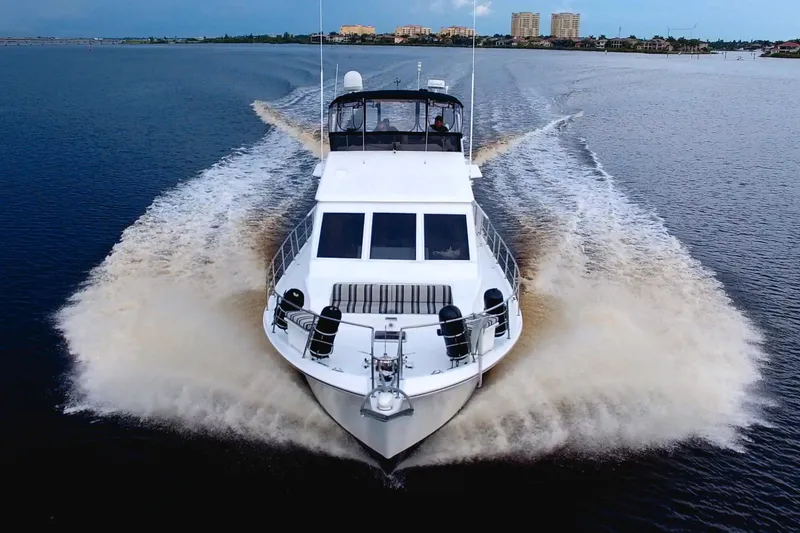Slide: The Image of 1988 Viking 63 Cockpit Motor Yacht cruising on open water, creating a dynamic wake. - 5
