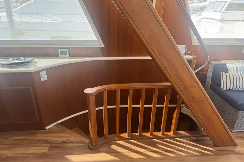 Slide: The Image of Interior of 1988 Viking 63 Cockpit Motor Yacht with wooden staircase and seating area. - 77