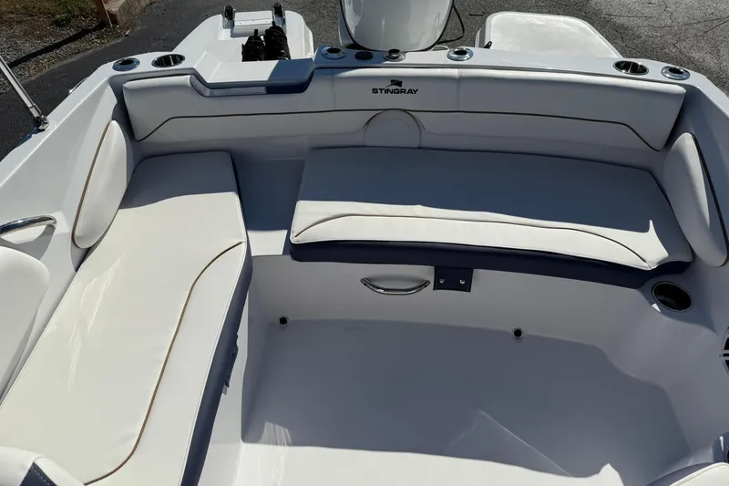 Slide: The Image of 2026 Stingray 182 SC boat interior with white cushioned seating and cup holders. - 11