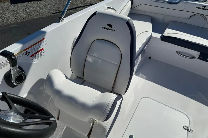 Slide: The Image of 2026 Stingray 182 SC boat interior with white seating and steering wheel. - 18