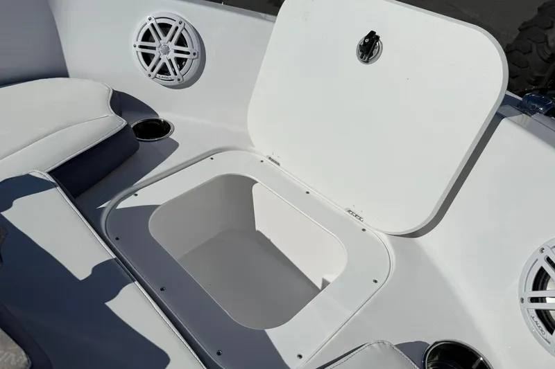 Slide: The Image of Open storage compartment on 2026 Stingray 182 SC boat with speaker and cup holder. - 21