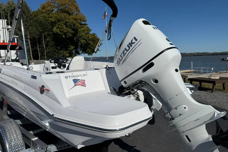 Slide: The Image of 2026 Stingray 182 SC boat with Suzuki outboard motor by a lake. - 3