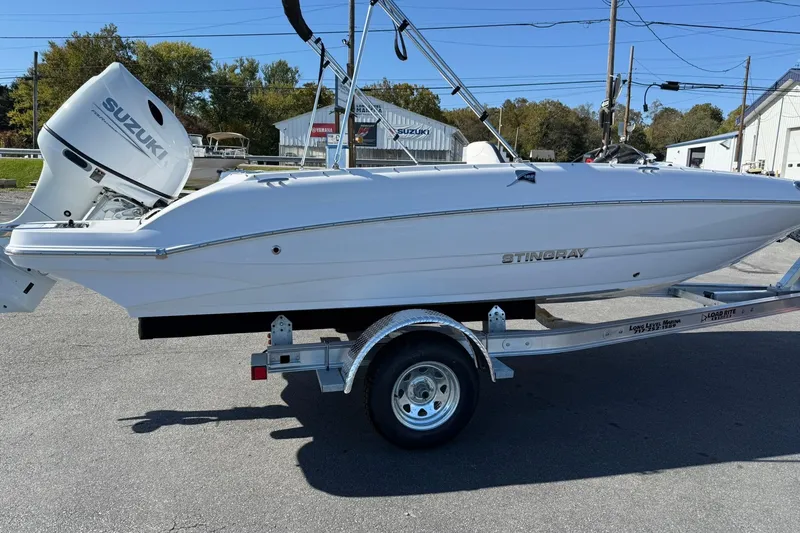 Slide: The Image of 2026 Stingray 182 SC boat on trailer with Suzuki outboard motor, parked outdoors. - 5