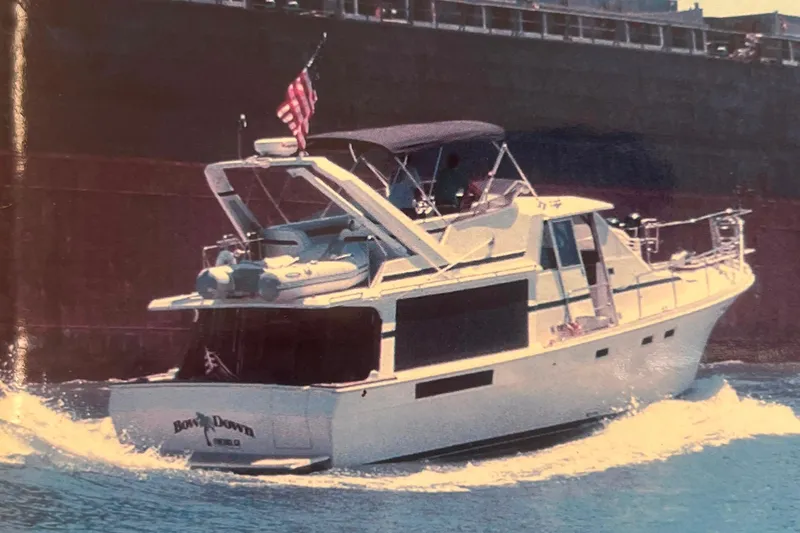 The Image of 1986 Bayliner 4550 Motoryacht cruising on open sea with American flag. - 0