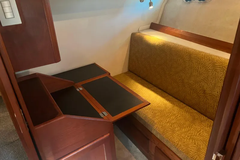 Slide: The Image of 1986 Bayliner 4550 Motoryacht interior with foldable table and cushioned seating. - 22