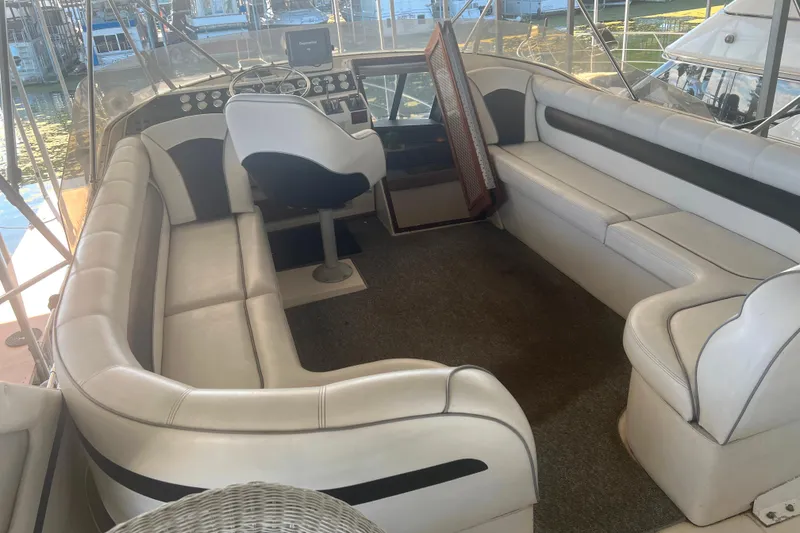 Slide: The Image of 1986 Bayliner 4550 Motoryacht flybridge with white seating and helm station. - 4