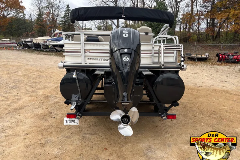 Slide: The Image of 2021 Ranger 223FC pontoon boat with outboard motor, parked on a dirt lot. - 3