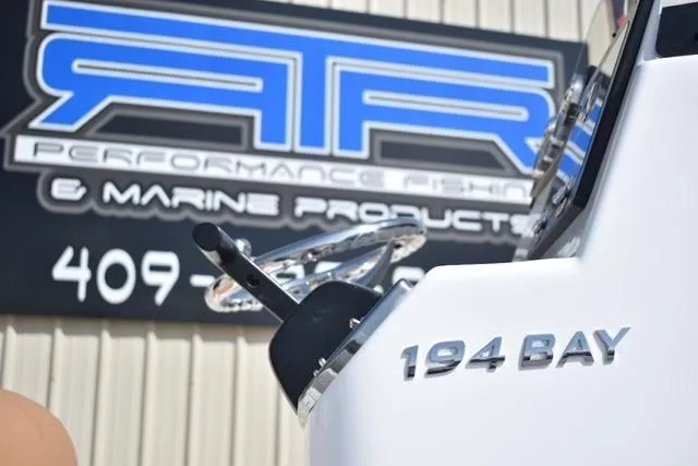 Slide: The Image of 2025 NauticStar 194 Bay boat near marine products sign. - 3