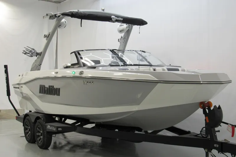 Slide: The Image of 2026 Malibu Wakesetter 21 LX boat on trailer in showroom setting. - 1